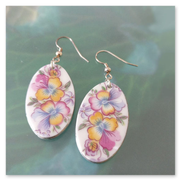 Aus einem alten Teller ausgeschnittene Stiefmütterchen-Motive wurden hier zu ovalem Ohrschmuck verarbeitet. 