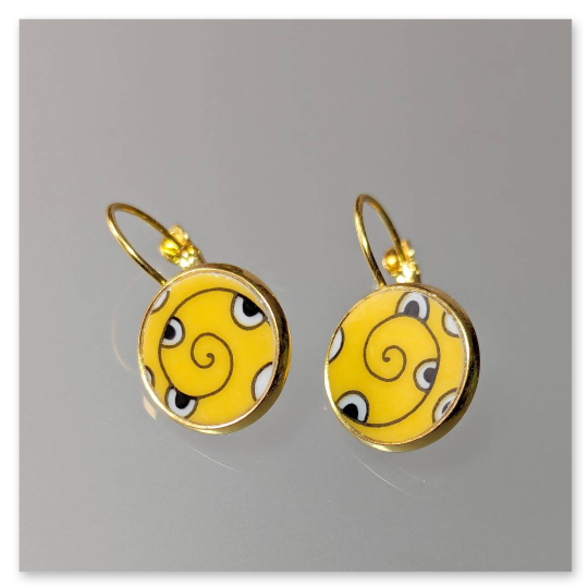 Diese goldfarbenen Ohrhänger sind Handmade-Produkte. Gefertigt aus einer Scherbe alten Porzellangeschirrs, vereinen sie Nachhaltigkeit mit individuellem Design. Das auffällige gelbe Muster mit spiralförmigem Motiv macht jedes Paar zu einem kleinen Blickfang.<br /><br />Die Fassungen sowie die praktische Klappbrisur bestehen aus robustem Edelstahl und sind angenehm zu tragen.