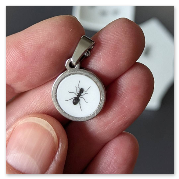 Kleiner Kettenanhänger mit einem Durchmesser von 15 mm. Die Fassung ist aus Edelstahl. Das Ameisenmotiv stammt aus dem ursprünglichen Porzellandekor eines Tellers und macht jede Scherbe zu einem kleinen Unikat.<br />